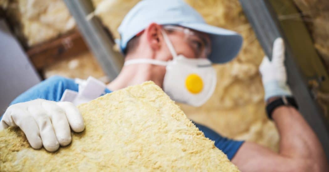 Mineral Rock Wool Insulating Concept Photo. Worker with Piece of Insulating Wool in Hands.